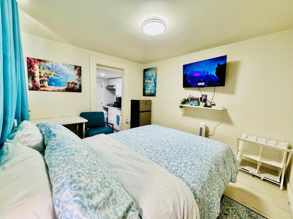 ein Schlafzimmer mit einem Bett und einem Fernseher an der Wand in der Unterkunft Cozy 1 Bedroom Mini Apartment 10 Mins to SeaTac Airport in Seattle