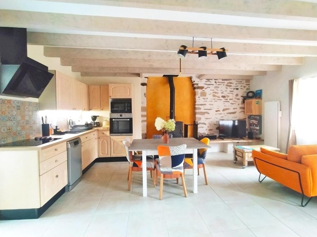 Una cocina con una mesa y sillas en una habitación. en Gîte Youna - Nature et charme breton entre Lizio et Josselin, en Lizio