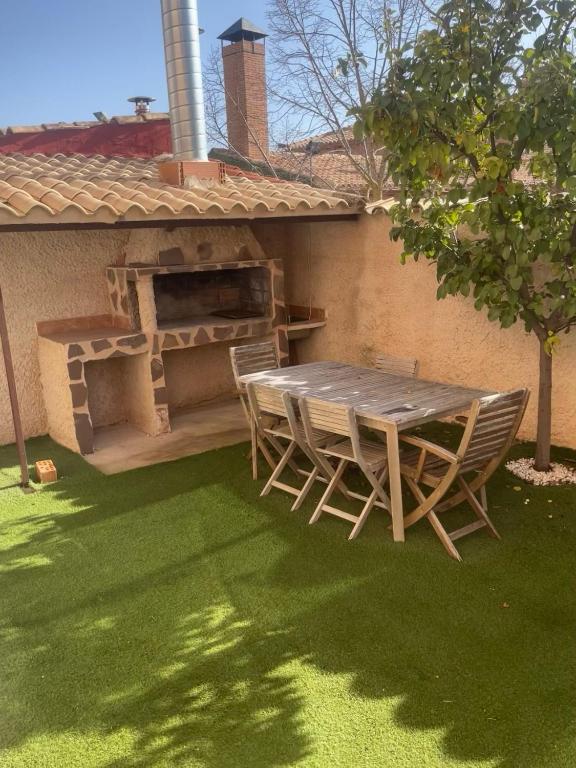a patio with a table and chairs on a lawn at Cuencaloft Villa Paraíso in Carrascosa del Campo