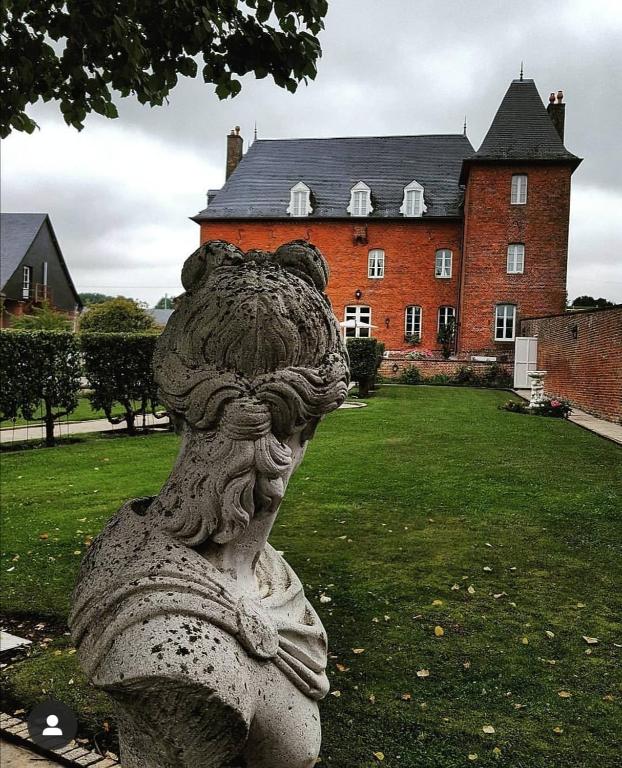 a statue of a girl in front of a building at Le Château d'Ognies in Dohis