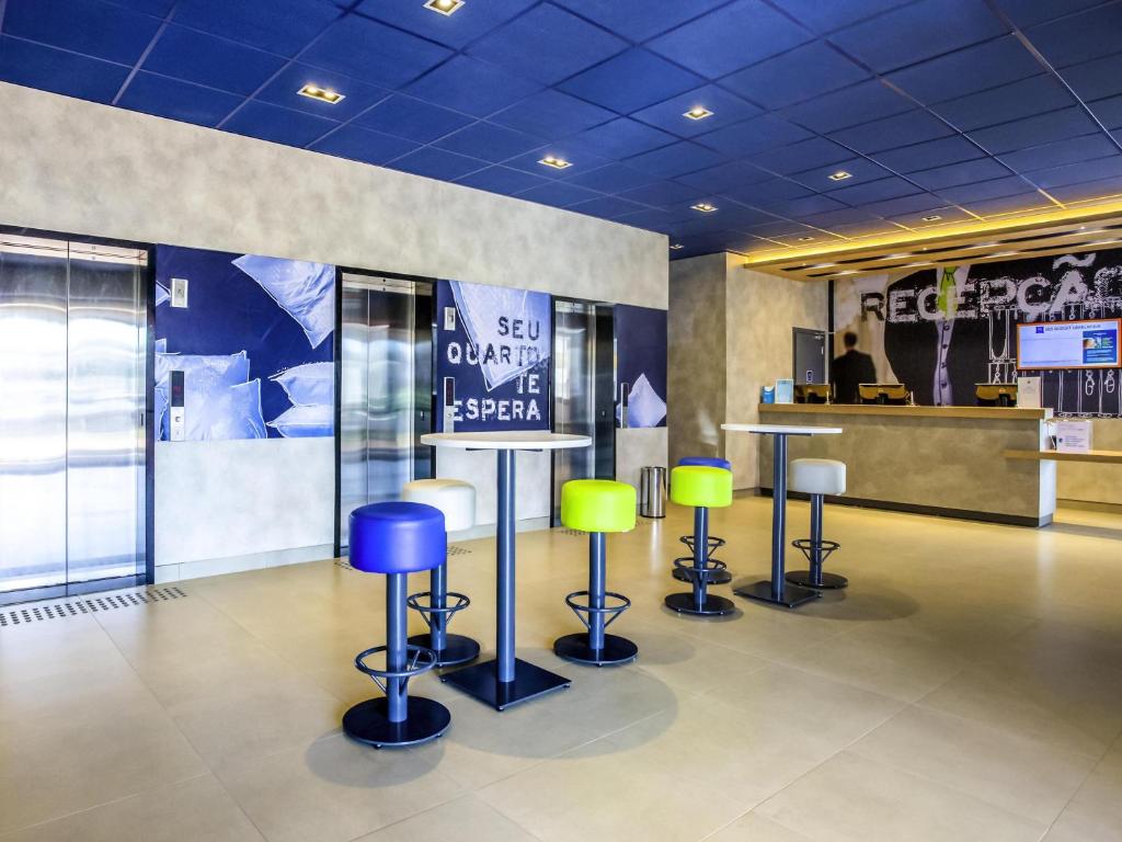 a room with stools and a sign in a store at Íbis Budget Uberlândia in Uberlândia