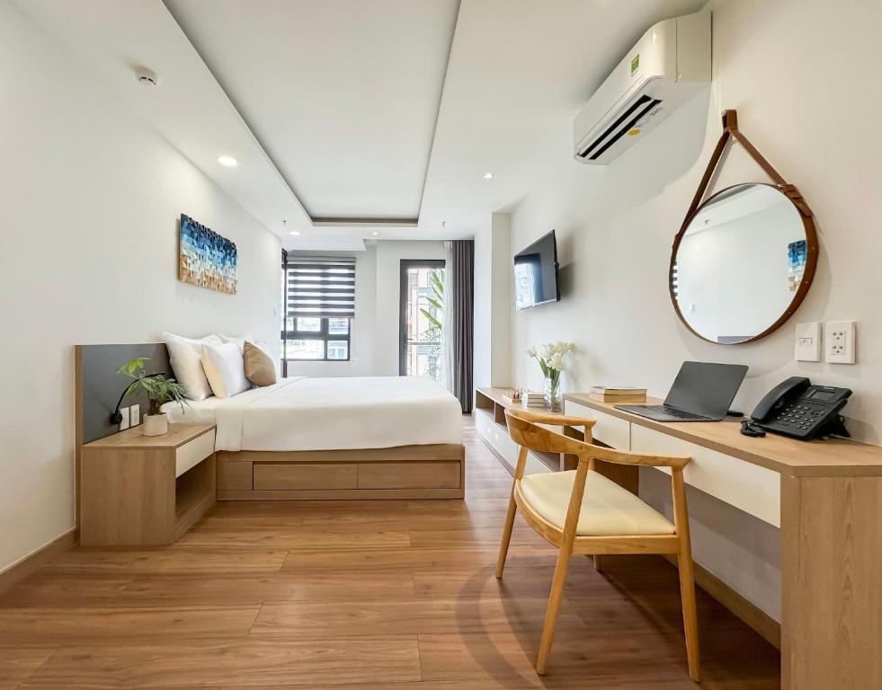 een slaapkamer met een bed en een bureau met een laptop bij Cityhouse - LightHouse SG in Ho Chi Minh-stad