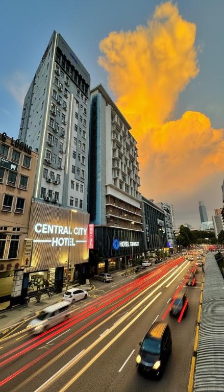 a busy city street with cars driving down a street at Central City Hotel at Chinatown in Kuala Lumpur