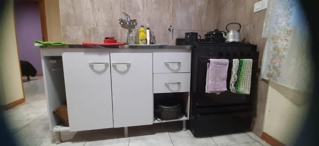 a kitchen with a stove and a white counter top at Apartamento in Olavarría