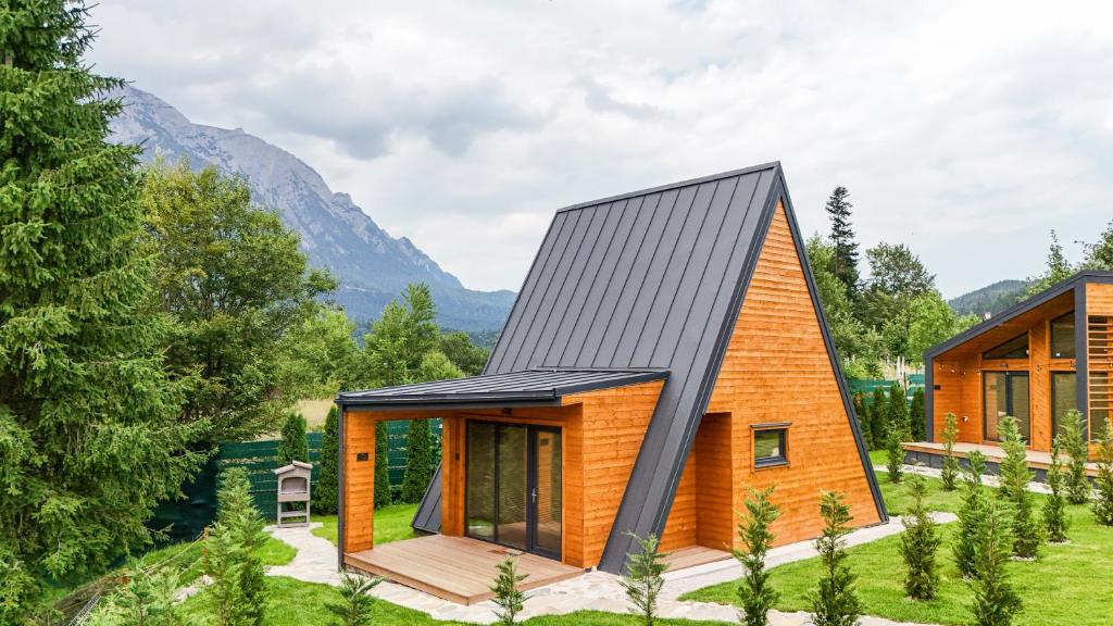 ein Haus im Wald mit schwarzem Dach in der Unterkunft A-Frame Villas in Buşteni