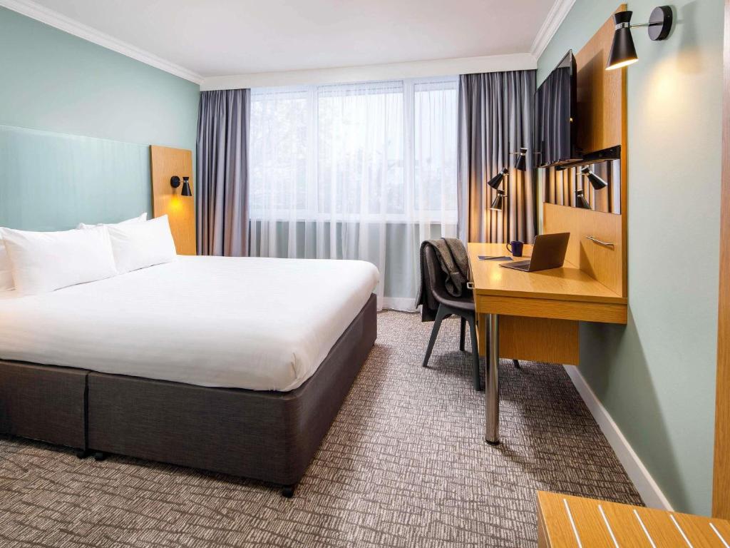 una habitación de hotel con una cama y un escritorio en The Harlow Hotel By AccorHotels, en Harlow