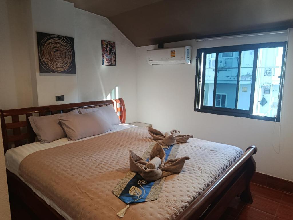a bedroom with a bed with two stuffed animals on it at Hop new guest House in Patong Beach