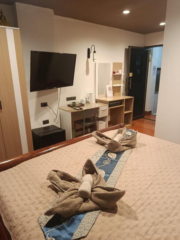 Hotel Hop new guest House, a bedroom with a bed with two towels on it at Hop new guest House in Patong Beach