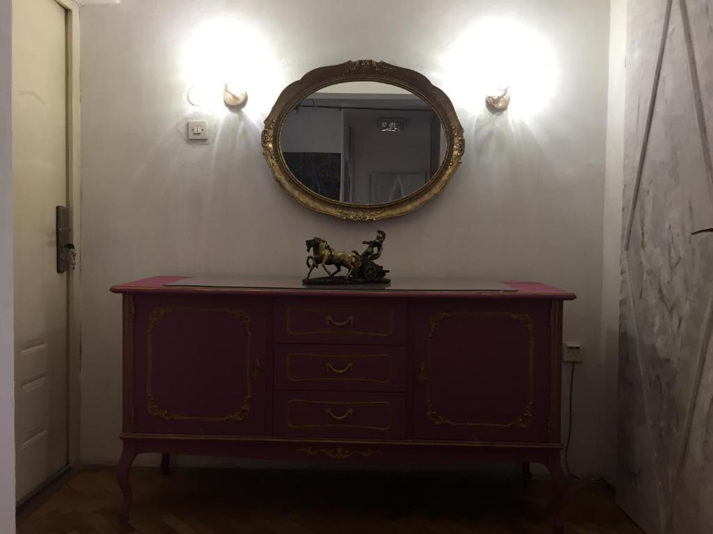 una cassettiera con uno specchio su una parete bianca di Аpartment Centаr a Skopje