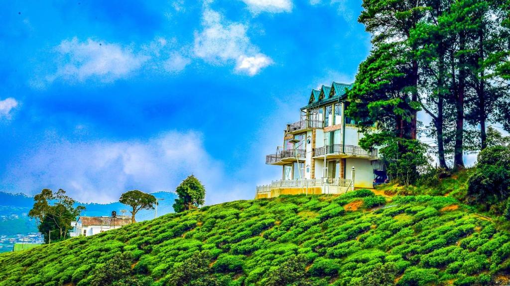een huis bovenop een heuvel bij Universal Green Hills Hotel in Nuwara Eliya