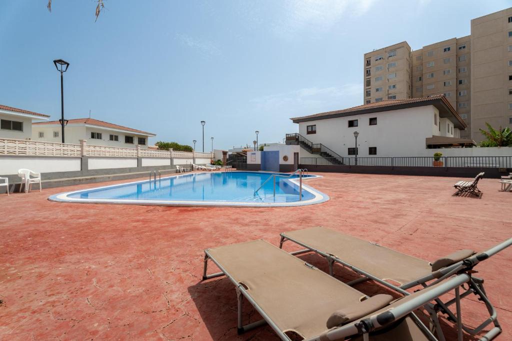 una piscina con 2 sedie a sdraio su un patio di Acaymo Sunset a Candelaria