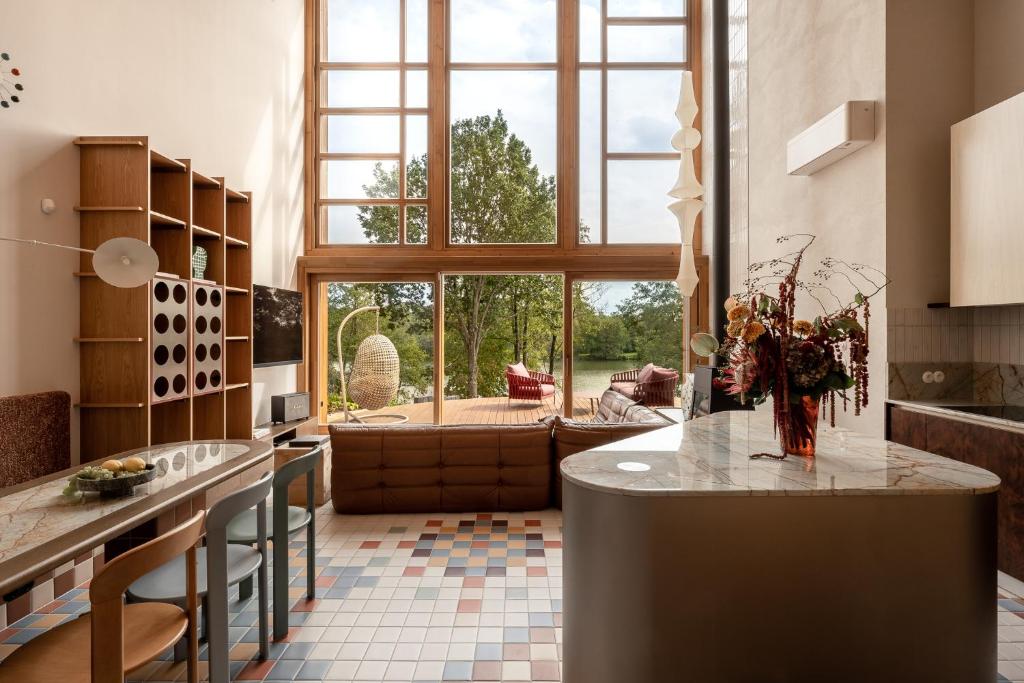 a kitchen with a large window and a living room at Kalbornia LAKE & POOL HOUSE by JWPM in Brzeźno Mazurskie