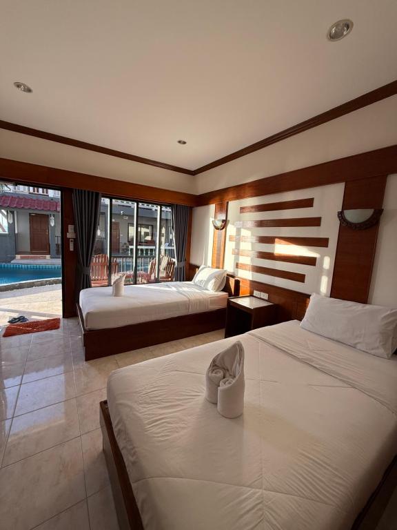 a hotel room with two beds and a balcony at Mr. Black Resort in Haad Rin