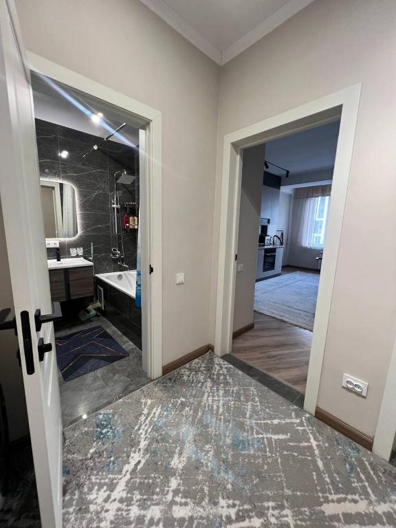 pokój z łazienką z umywalką i lustrem w obiekcie SunHouse w mieście Biszkek