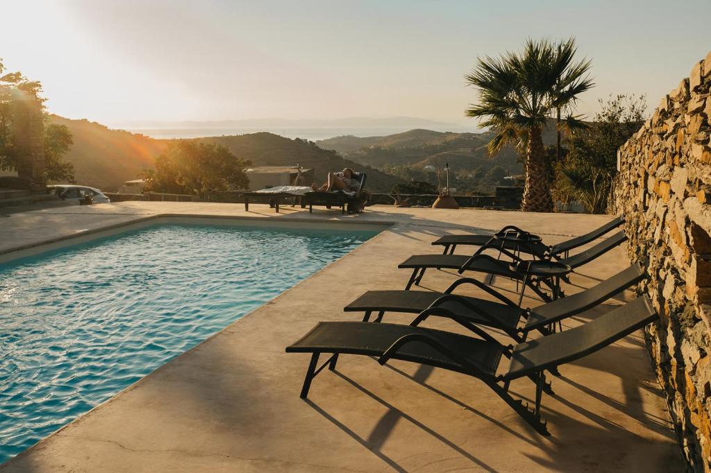 a group of chairs sitting next to a swimming pool at Kea Villa Thea by A&D Properties in Otziás