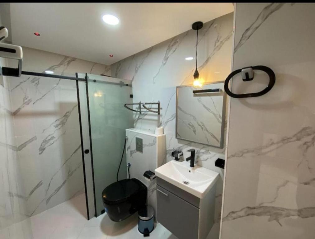 a bathroom with a toilet and a sink and a shower at les appartements vip madinat bades alhoceima in Al Hoceïma