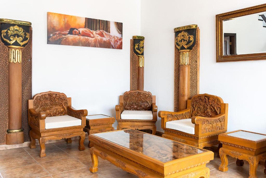 a room with chairs and a table and a mirror at Aretina's Lanzarote Retreat in Costa Teguise