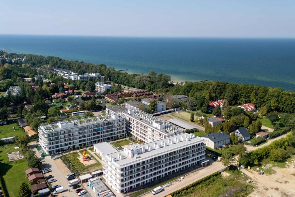 an aerial view of a white building next to the ocean at Premium & Elegance Apartments with Pool by Noclegi Renters in Sianozety