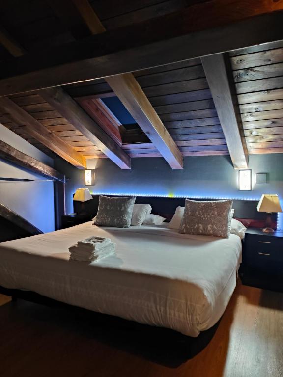 a large bed in a room with wooden ceilings at Aiestaenea Apartamentos Rurales in Isaba