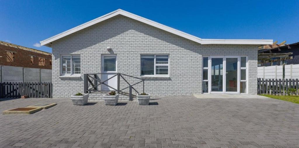 a house with a brick driveway in front of it at Ondermaat in Agulhas