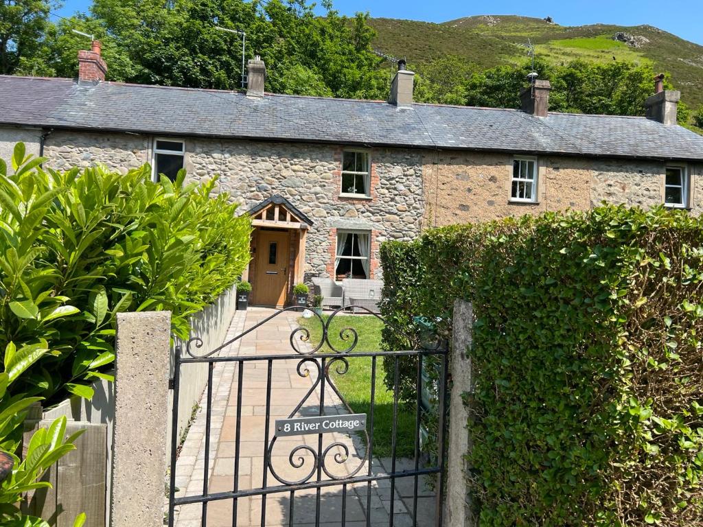 an entrance to a stone house with a gate at River Cottage in Conwy