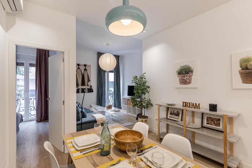 a dining room and living room with a table and chairs at Waou Chamberi V - Alquiler Corta Duración in Madrid