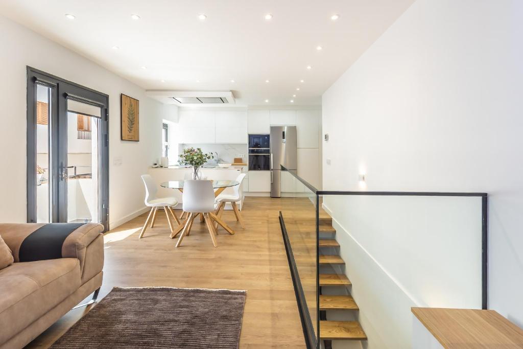 a living room with a staircase and a table with chairs at Modern Balcony House - Solarium Terrace - Parking in Arafo