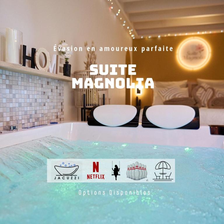 a hot tub in a hotel room with a sign at Suite Magnolia in Évreux