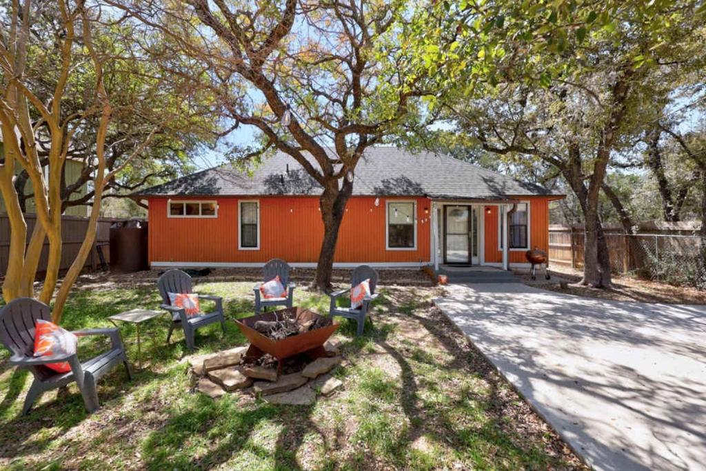 a yard with chairs and a table and a house at Stunning Lake Travis Retreat in Austin in Buffalo Gap
