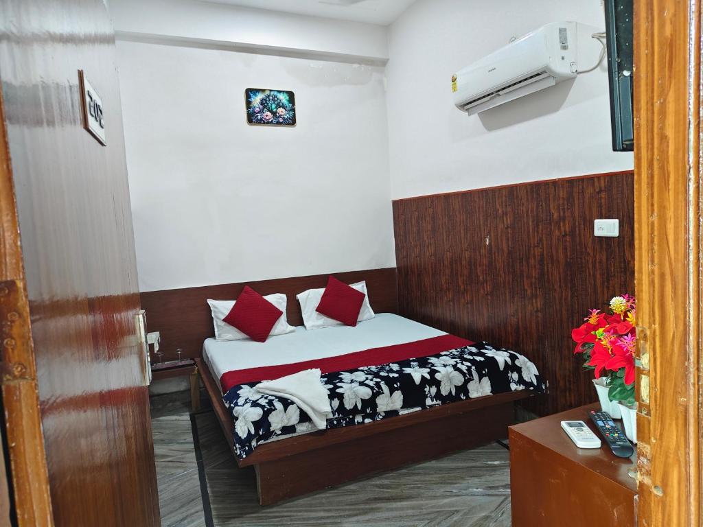 a bedroom with a bed with red pillows at Hotel Saroj Residency in Jāmb