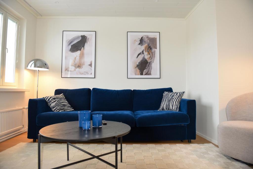 Una sala de estar con un sofá azul y una mesa. en Penthouse Kemi, en Kemi