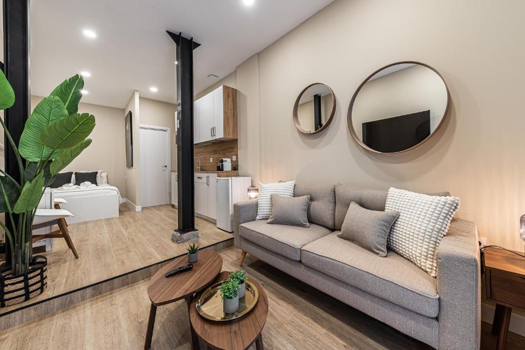 a living room with a couch and a mirror at Waou Essence II Lavapiés - Alquiler Corta Duración in Madrid