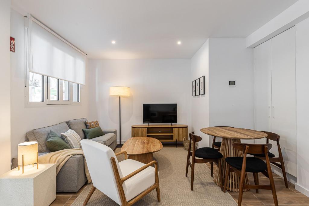 a living room with a couch and a tv and a table at Waou Best IV Madrid Rio in Madrid