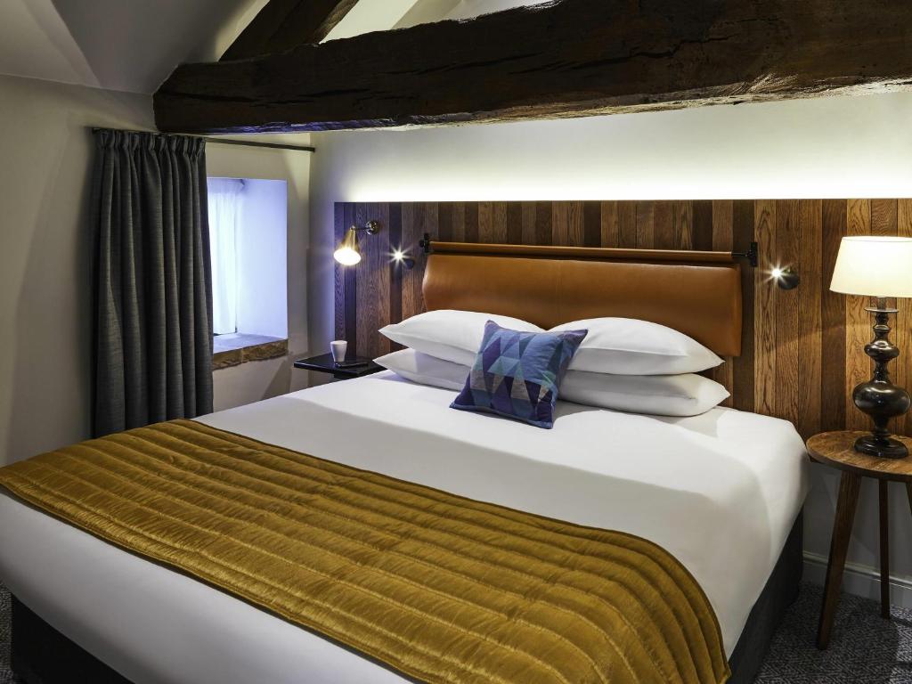 Un dormitorio con una cama grande con una manta amarilla. en Mercure Barnsley Tankersley Manor Hotel, en Barnsley
