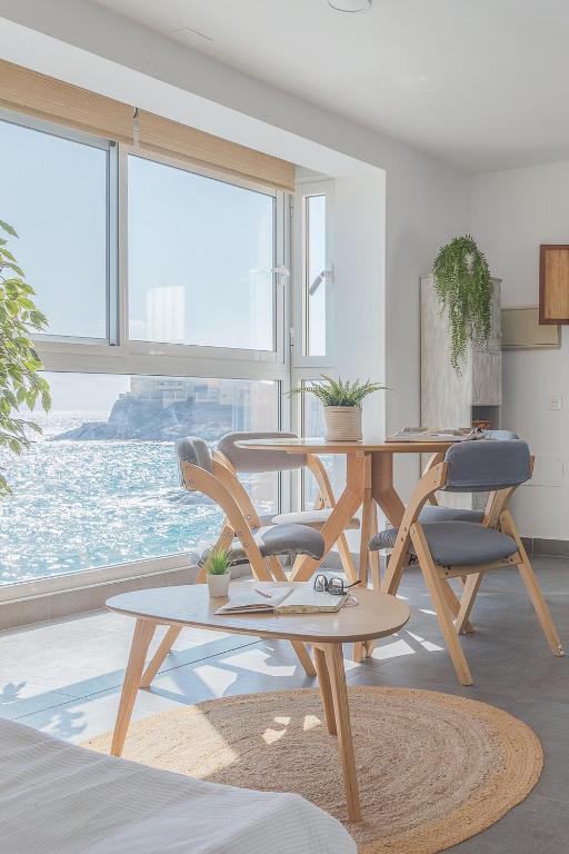 a living room with a table and chairs and a window at La Casita Masahug in San José