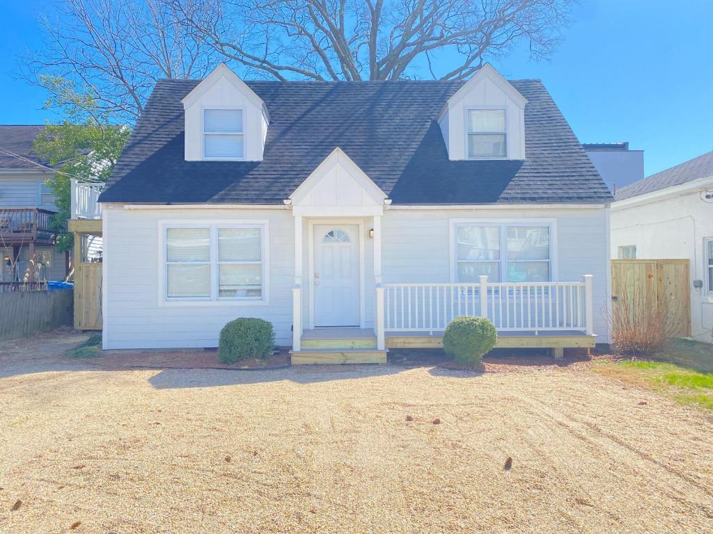 a white house with a porch with a blue door at 508 A The Shore Break Cottage in Virginia Beach