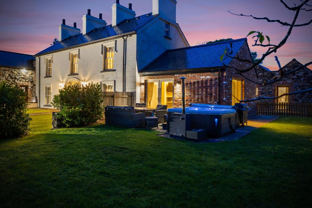 una casa grande con césped delante en The Farmhouse at Corrstown Village, en Portrush