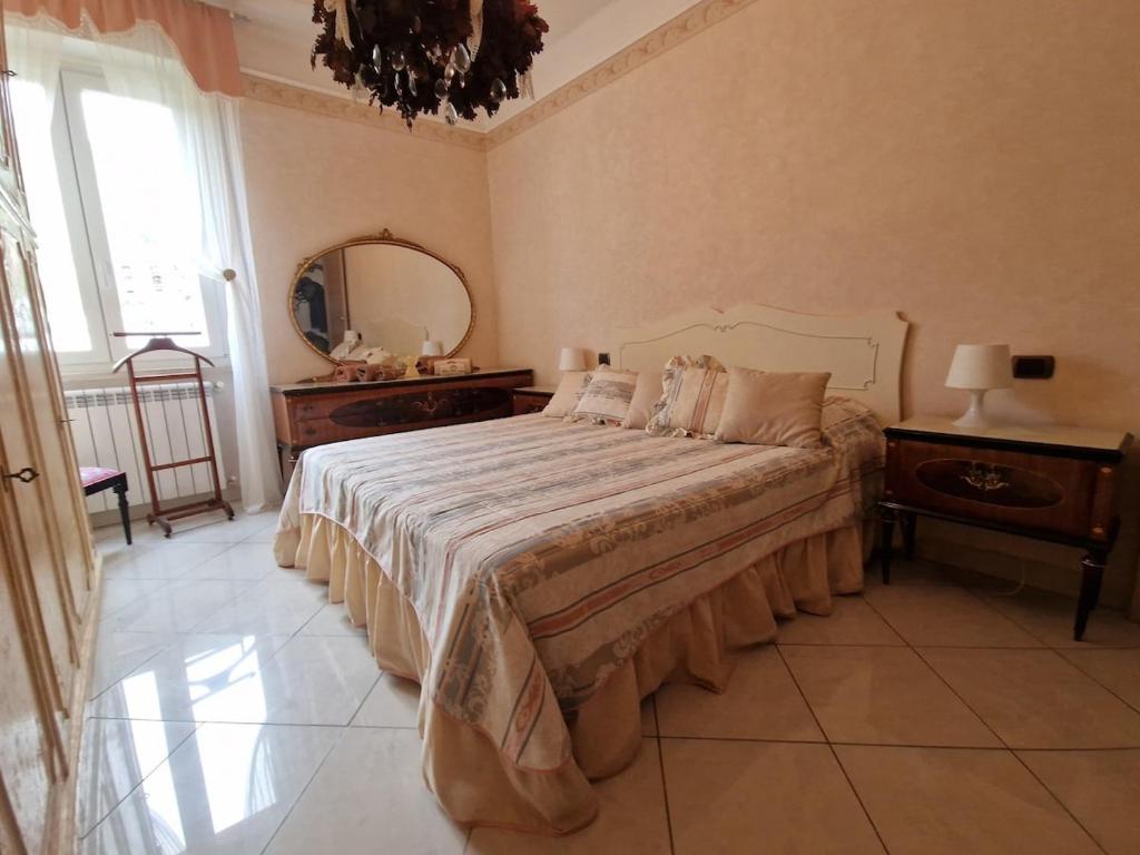 a bedroom with a large bed and a mirror at Finestra sul Mare - La Guardiana del Golfo in Lerici