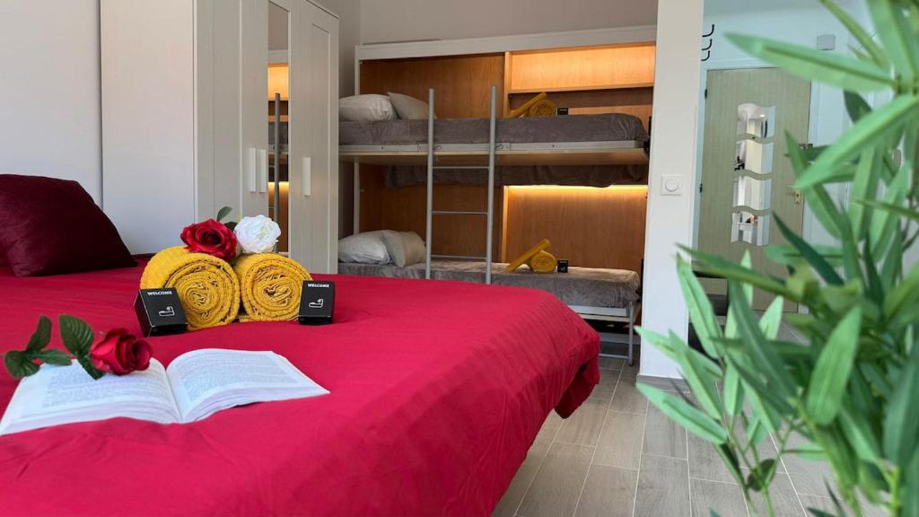 a bedroom with a red bed with an open book at LE COCOON - Proche Centre - Climatisation - Wifi in Menton