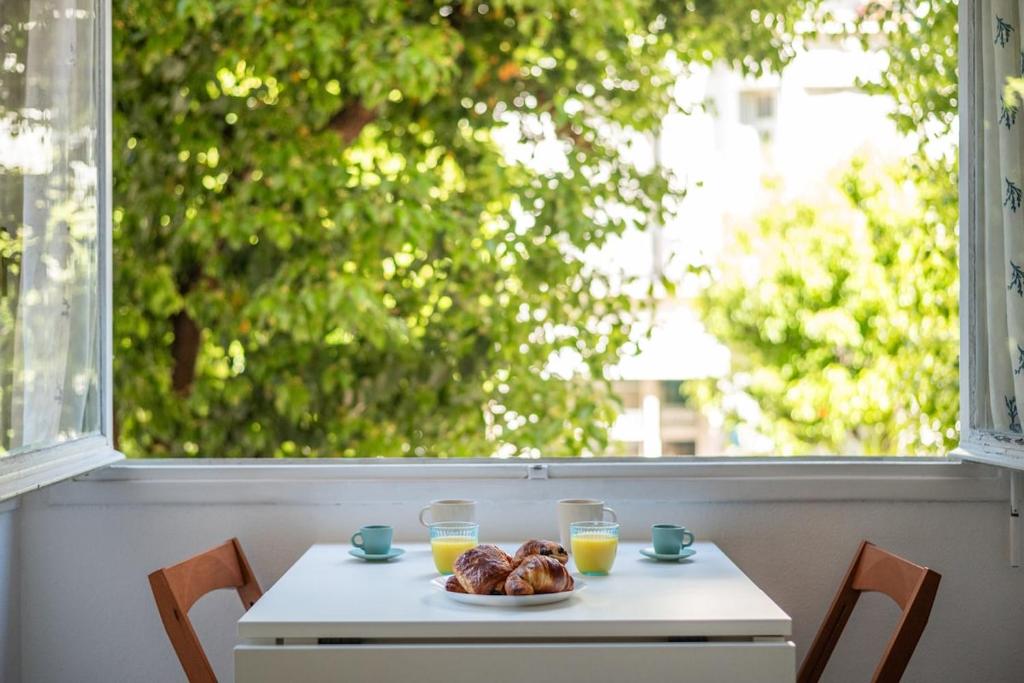 una mesa con un plato de bollería y dos vasos de zumo de naranja en LE GLORIA - Hyper Centre - Proche Mer - Wifi, en Menton