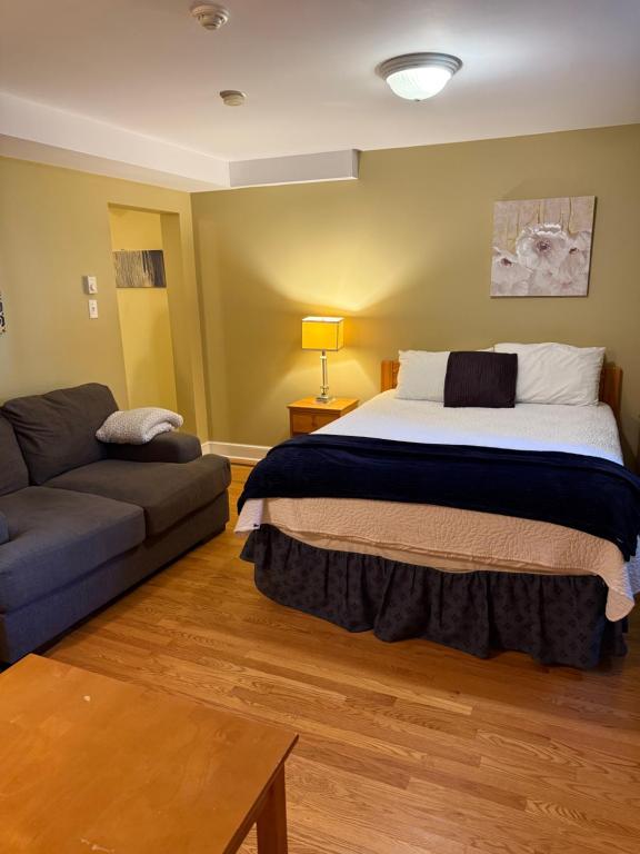 a bedroom with a large bed and a couch at Midstream Manor Unit 1, Studio in St. John's