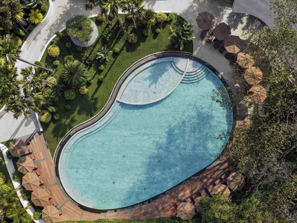 an overhead view of a swimming pool in a resort at Mövenpick Hotel Bangkok Ploenchit BDMS in Bangkok