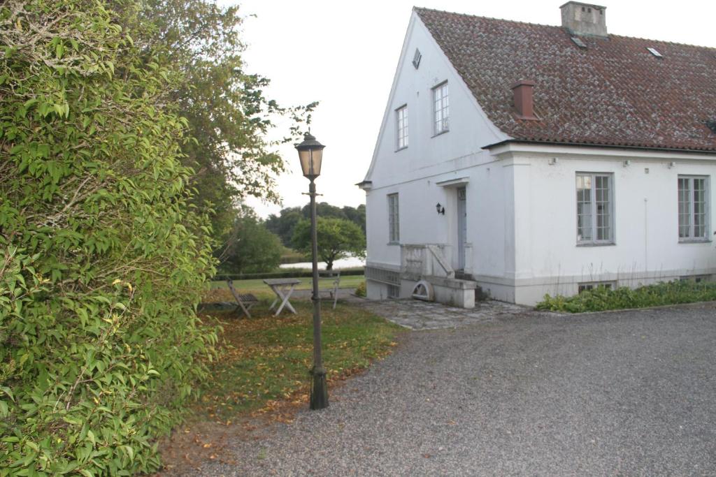 a white house with a street light in front of it at Gästlägenhet in Sövde