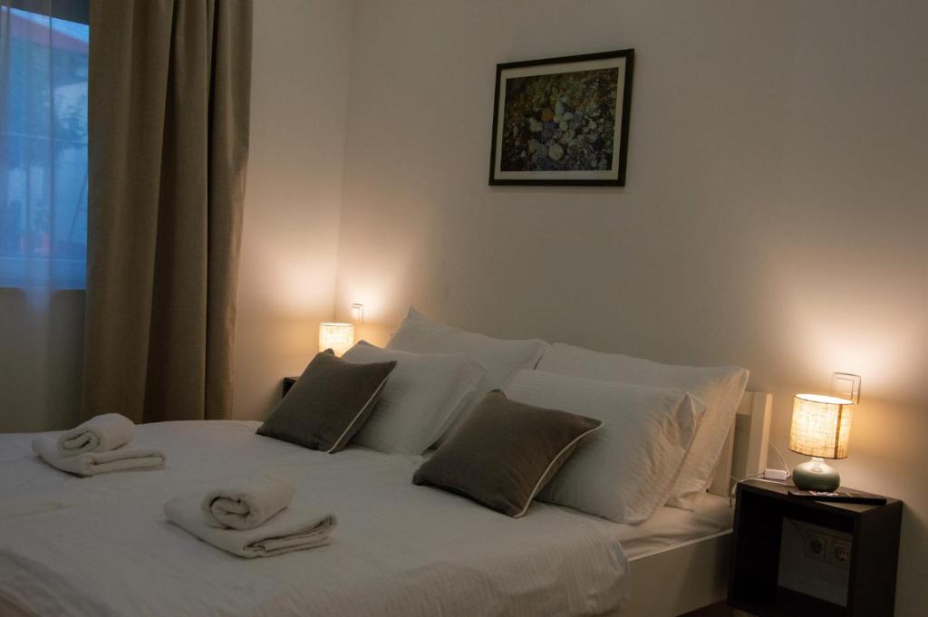 a bedroom with a white bed with towels on it at Apartman Nora in Široki Brijeg