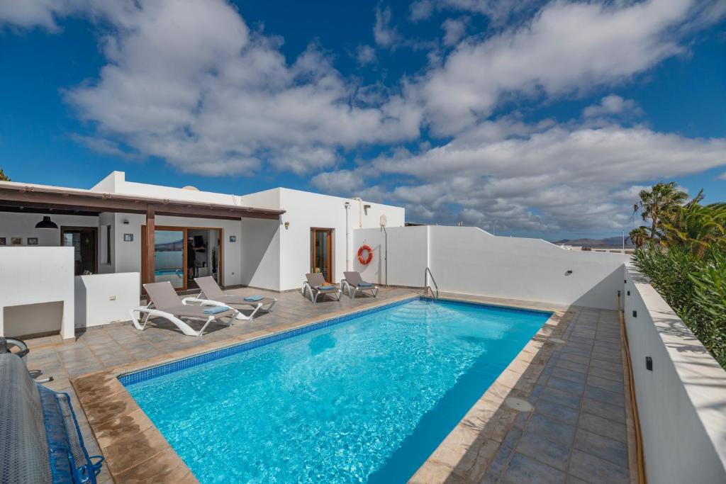 a villa with a swimming pool and a house at Villa Nitho in Playa Blanca