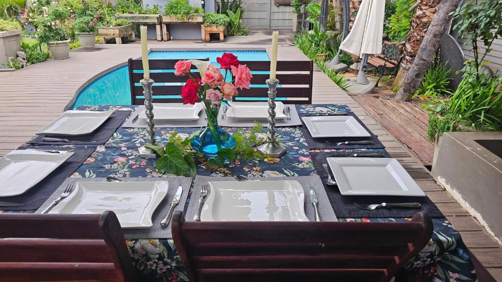 einen Esstisch mit Blumen darüber in der Unterkunft Rose Cottage Vintage room in Pretoria