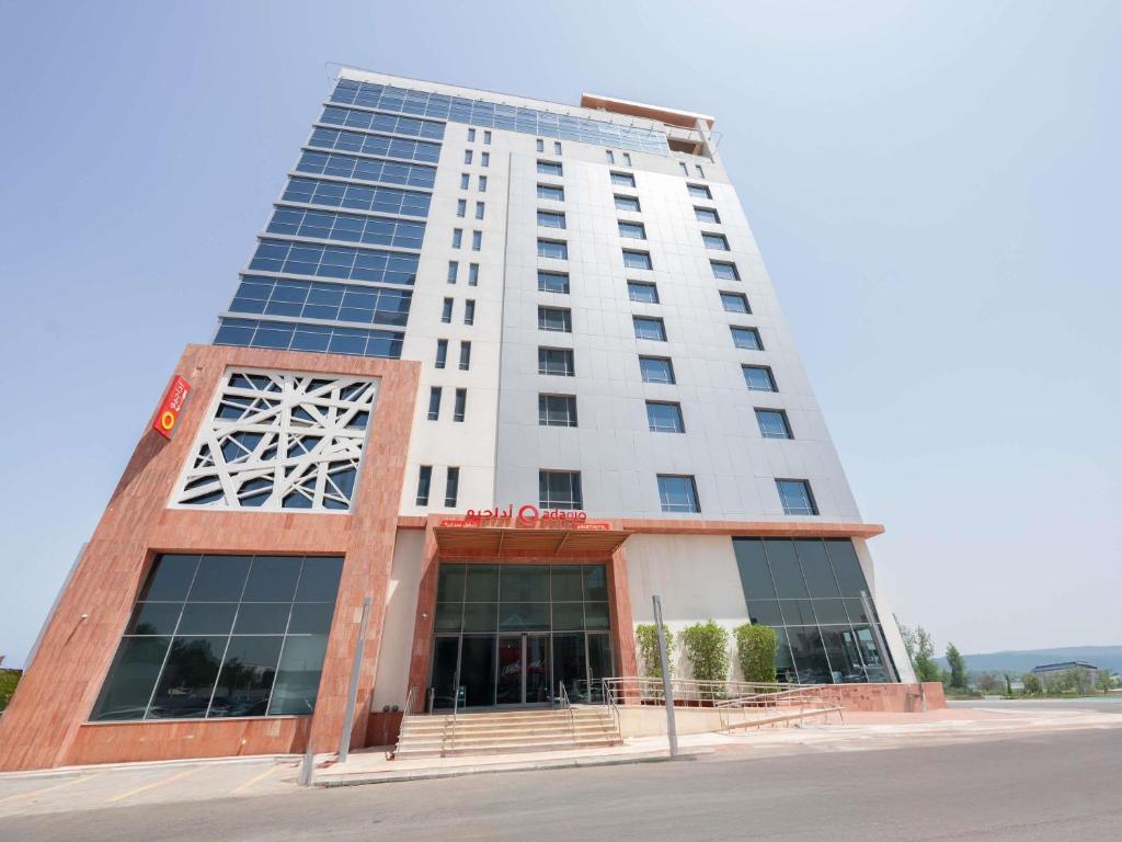 ジッダにあるAdagio Jeddah City Centerのたくさんの窓がある背の高い白い建物