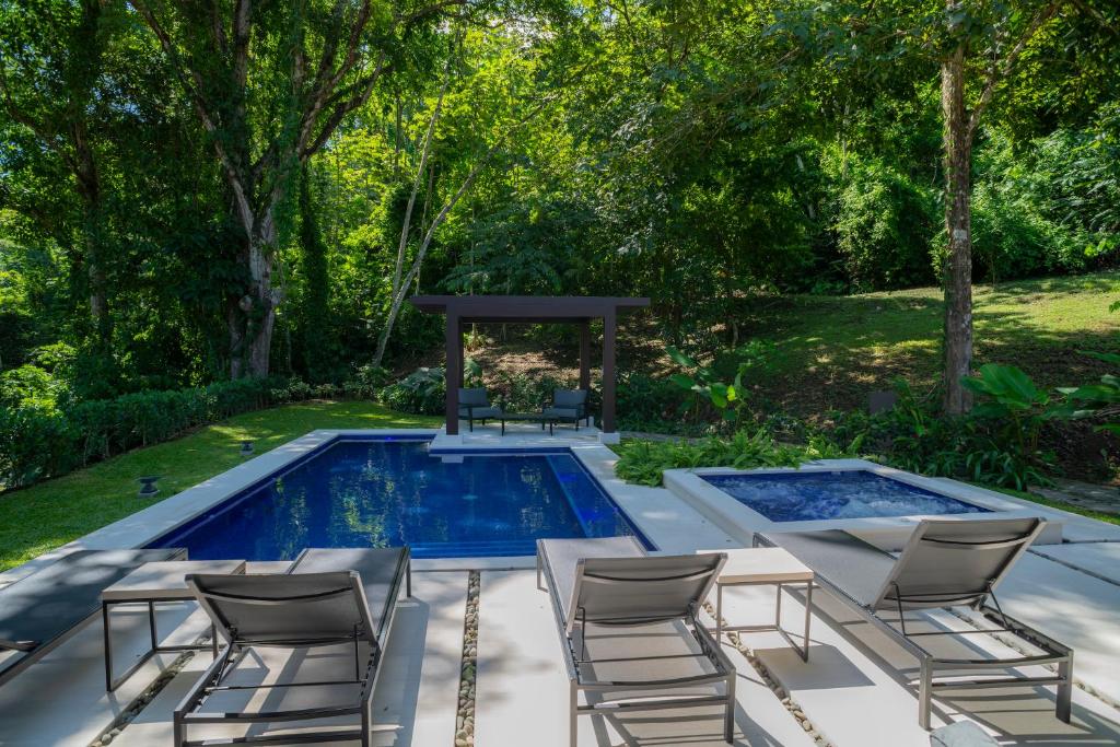 una piscina con sillas y un cenador en Casa Selva Tica 6 bdr pool golf view in Los Suenos, en Herradura