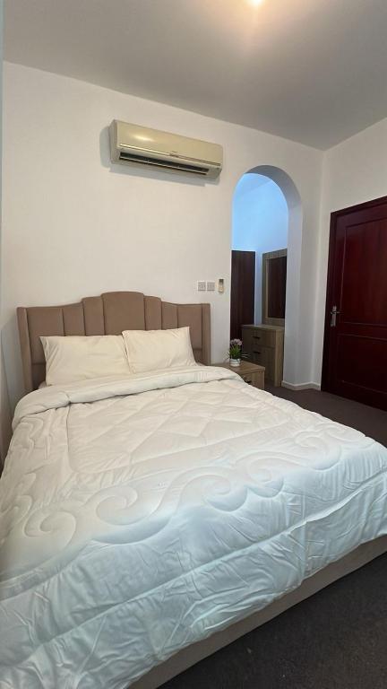 Una cama blanca grande en un dormitorio con ventana. en Khalifa A Home Stay Small Room, en Sabkhah