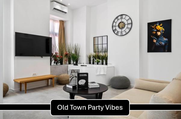 a living room with a couch and a clock on the wall at Joy Social Apartment in Bucharest